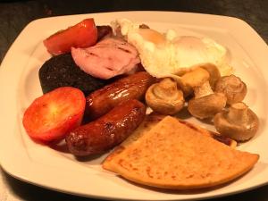 a plate of breakfast food with eggs sausage and mushrooms at The George Hotel in Montrose