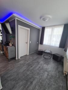 ein leeres Wohnzimmer mit einer Tür und einem Tisch in der Unterkunft Pension Zwei A in Leverkusen