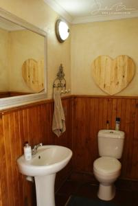 Un baño con inodoro y lavabo y dos corazones en la pared. en Karoo Gariep Tented Camp, en Hanover Road