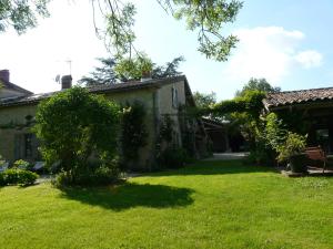 a yard in front of a house with a tree at Les Lebes - La petite maison in Sempesserre