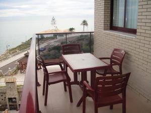 a table and chairs on a balcony with a view of the ocean at Aparthotel El Faro in Cullera