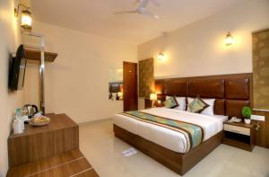 Habitación de hotel con cama y TV en Atithi Suites - An AHG Hotel, en Greater Noida