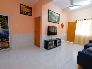 a living room with a tv and a couch at Mui Gim Homestay 大港 美景民宿 in Sungai Besar