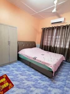 a small bedroom with a bed and a cabinet at Mui Gim Homestay 大港 美景民宿 in Sungai Besar