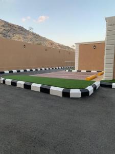 un campo de hierba en medio de un estacionamiento en منتجع حديقة الوسام en Taif