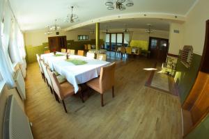 a large dining room with a white table and chairs at Dom Gościnny Pod Górą in Chełmno