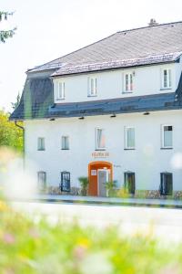 um grande edifício branco com uma porta vermelha em Velden24 - create your own stay em Velden am Wörthersee