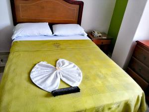 a heart shaped hat on a bed with a phone at HOTEL YORYTANIA BOUTIQUE in Pitalito