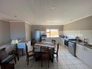 a kitchen with a table and chairs in a room at Relax & Recharge in Boggomsbaai