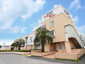 a building with a palm tree in front of it at Hotel Fine Garden Senboku in Sakai