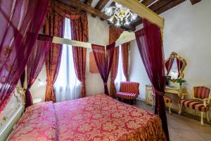 a bedroom with a canopy bed with purple curtains at Hotel Al Vagon in Venice