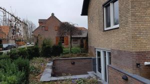 a brick house with a garden in front of it at Vakantie-appartement Oppe Donck met sauna in Posterholt