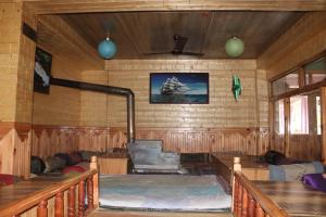 a room with wooden walls and a room with couches at Third Eye Tosh in Tosh