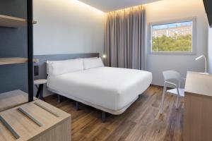 una habitación de hotel con una cama y una mesa en B&B HOTEL Madrid Alcorcón, en Alcorcón 37 fotos más