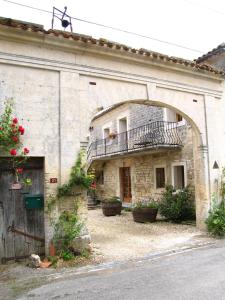 an old building with a balcony on the side of it at La Cour des Cloches in Mainxe