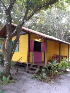 a yellow house with colorful paint on it at Casinha Amarela Chales Boipeba in Ilha de Boipeba