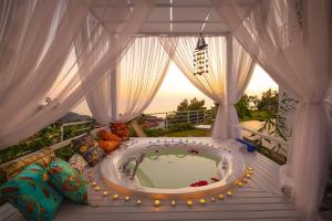 a room with a hot tub on a balcony at Highclere Hotel and Spa in Faralya