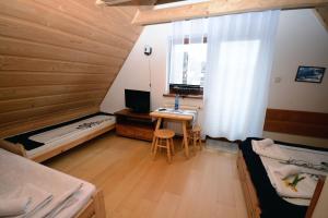 une chambre avec deux lits et un bureau avec un ordinateur dans l'établissement Dom Z Witrażami, à Bukowina Tatrzańska