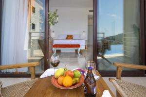 a table with a bowl of fruit and a glass of wine at Highclere Hotel and Spa in Faralya