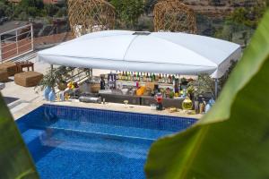 a pool with a bar with an umbrella next to it at Highclere Hotel and Spa in Faralya