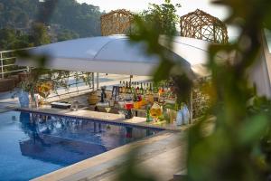 a swimming pool with a bar next to a swimming pool at Highclere Hotel and Spa in Faralya