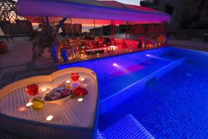 a pool with a table with a bowl of fruit and candles at Highclere Hotel and Spa in Faralya