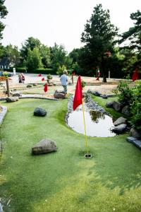 een golfbaan met een rode vlag in het gras bij Feriepark Langeland Ristinge (Feriepark Langeland) in Humble