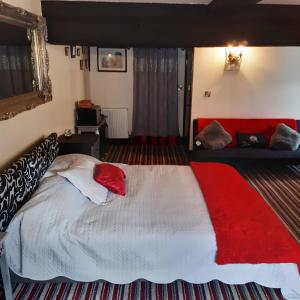 a bedroom with a large bed with a red blanket at The Saracens Head Old Lounge in Skegness