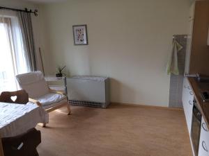 Zimmer mit einem Bett, einem Stuhl und einem Fenster in der Unterkunft Haus Eiter in Nassereith