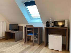 a room with a desk with a computer and a tv at LA GIENDROTAIS in Corseul