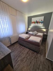 a bedroom with two beds and a painting on the wall at Pension Zwei A in Leverkusen