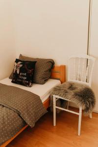 a bedroom with a bed and a chair with a pillow at Apartman Balkon in Mostar