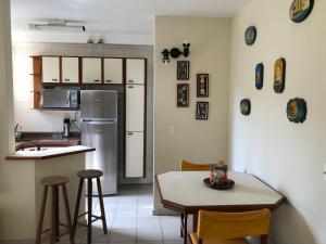 eine Küche mit einem Kühlschrank sowie einem Tisch und Stühlen in der Unterkunft Riviera Green in Riviera de São Lourenço