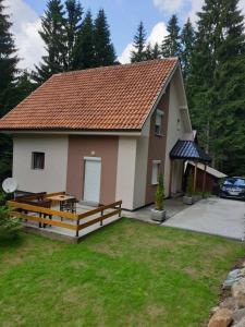 a small house with a porch and a yard at Studio MK in Kopaonik