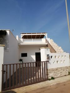 a white house with a gate and stairs at Casa vacanze SALENTO BELLA VISTA in Capilungo