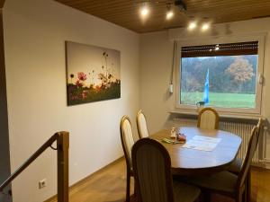 una sala da pranzo con tavolo, sedie e finestra di Ferienwohnung auf dem Land und trotzdem stadtnah. a Herford