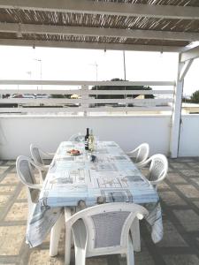 a white table with white chairs and a table with newspapers on it at Casa vacanze SALENTO BELLA VISTA in Capilungo