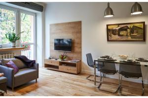 sala de estar con mesa, sofá y TV en Kredytowa Warsaw Apartment, en Varsovia