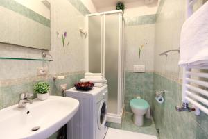 La salle de bains est pourvue d'un lavabo et d'un lave-linge. dans l'établissement San Pietro's Home, à Rome