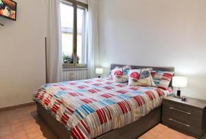 una camera da letto con un letto con un copriletto colorato e una finestra di San Pietro's Home a Roma