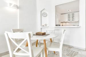 ein weißes Esszimmer mit einem weißen Tisch und Stühlen in der Unterkunft Apartamento Altamira in Adeje