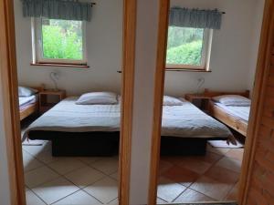 two beds in a room with two windows at domek letniskowy w Kujankach in Kujan