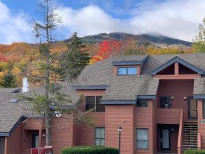 a house with a mountain in the background at Trail Creek: Walk to lifts, ski home! Closest unit to lifts, ski home trail, sports center in Killington