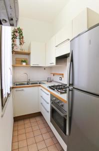 a kitchen with white cabinets and a stainless steel refrigerator at San Pietro's Home in Rome