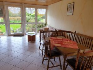 a living room with a table and chairs and windows at Ferienwohnungen - Gästehaus Gertrud Moog- in Rust
