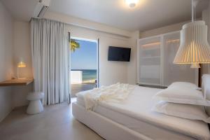 a bedroom with a bed with a view of the beach at Akrogiali Beach Hotel Apartments in Malia