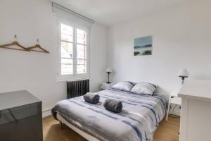 a white bedroom with a bed with two pillows on it at MAISON MODERNE ET SPACIEUSE AU CENTRE DE DEAUVILLE in Deauville