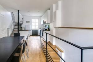 a kitchen and dining room with white walls and a black table at MAISON MODERNE ET SPACIEUSE AU CENTRE DE DEAUVILLE in Deauville