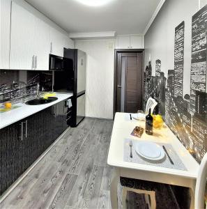 uma cozinha com um balcão branco num quarto em Атмосферная 1-к квартира м Левобережная em Kiev