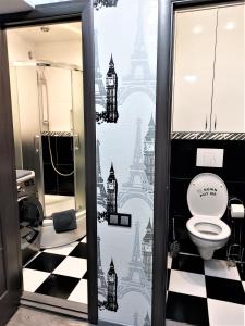 La salle de bains est pourvue de toilettes et d'un sol en damier. dans l'établissement Атмосферная 1-к квартира м Левобережная, à Kiev